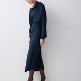 Woman wearing a navy blue dress against a white background