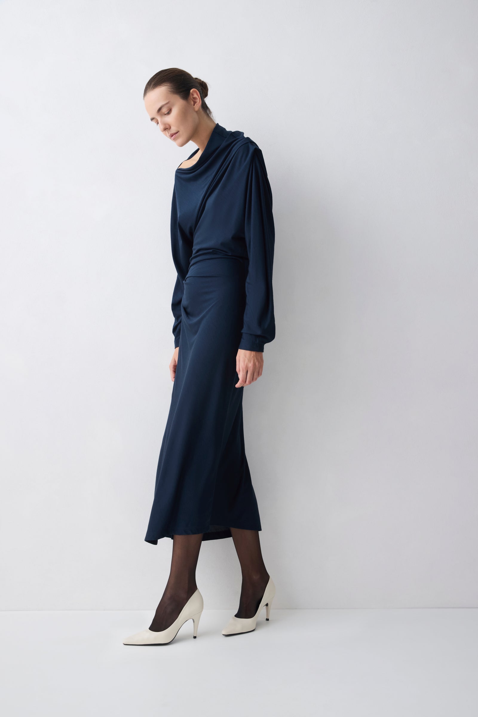 Woman wearing a navy blue dress against a white background