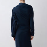Person wearing a long navy dress against a white background