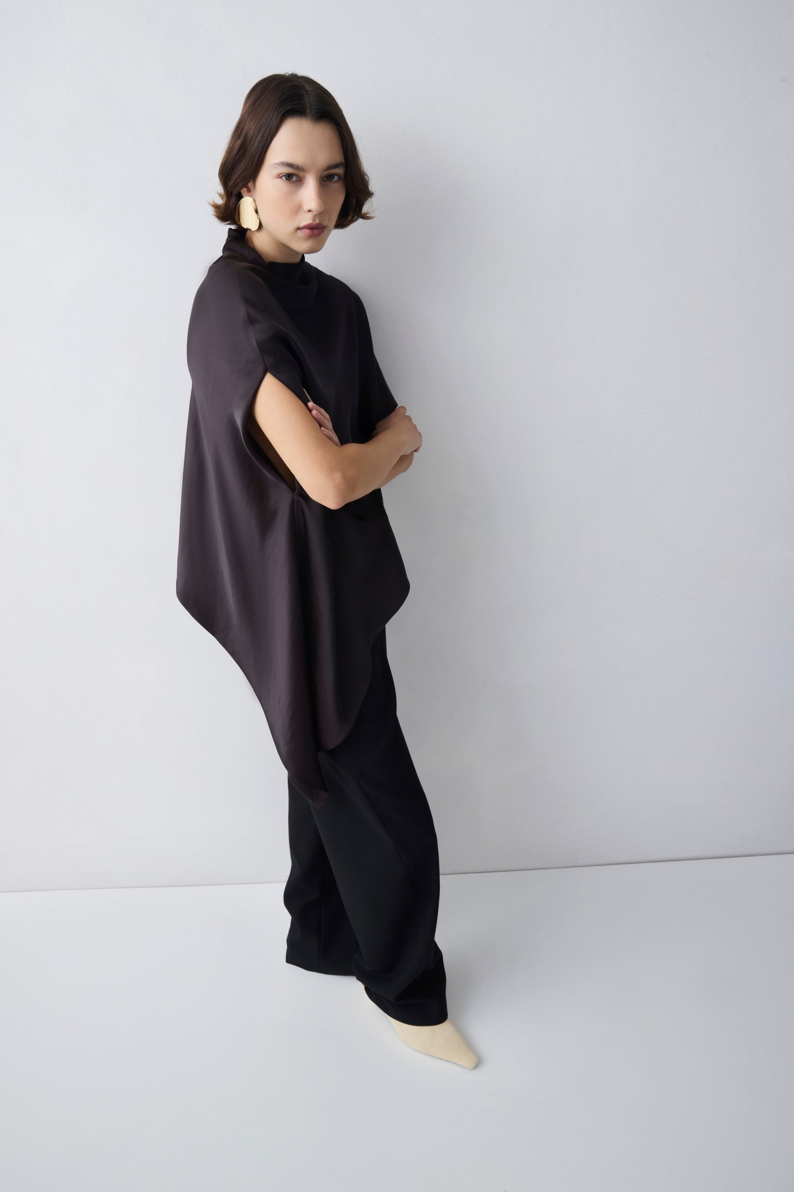 Person wearing a black outfit against a white background