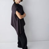 Person wearing a brown and black outfit against a white background