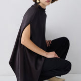 Person wearing a brown outfit with a cape on a white background