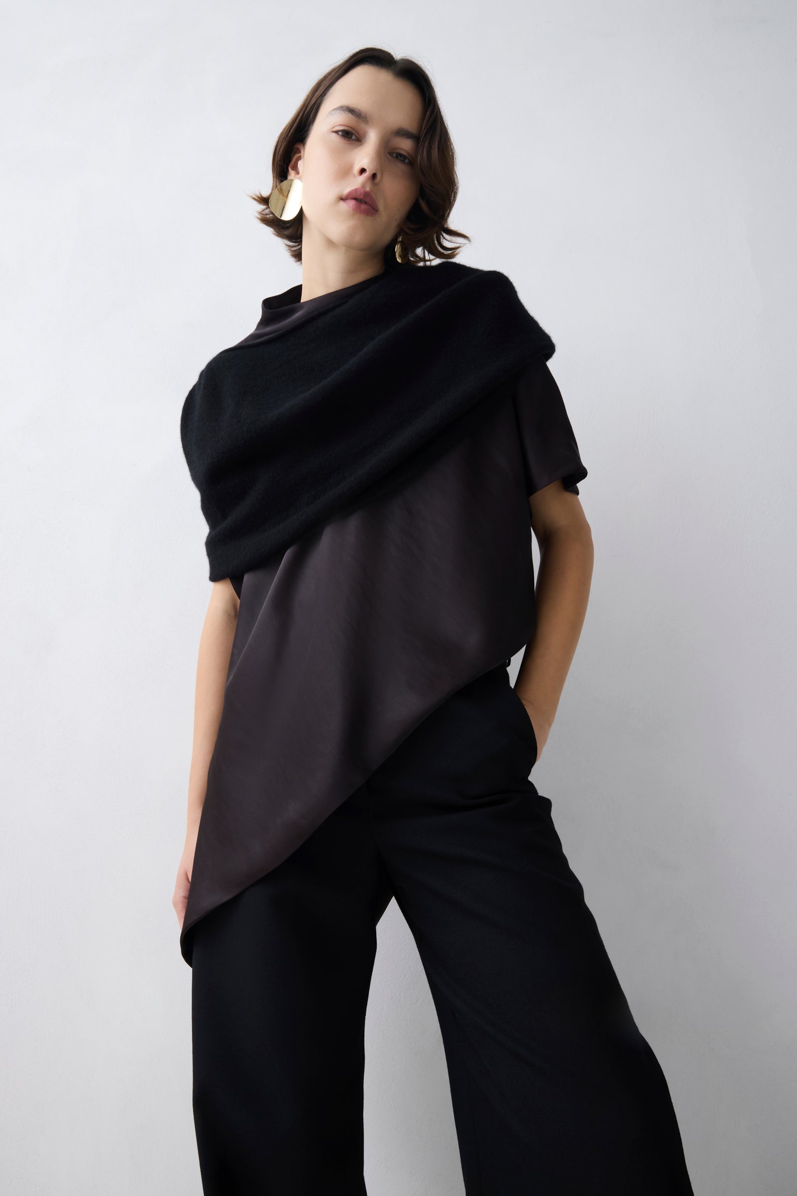 Person wearing a black outfit against a white background