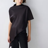 Person wearing a brown top over a black outfit on a white background