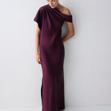 Woman wearing a purple off-shoulder gown against a white background