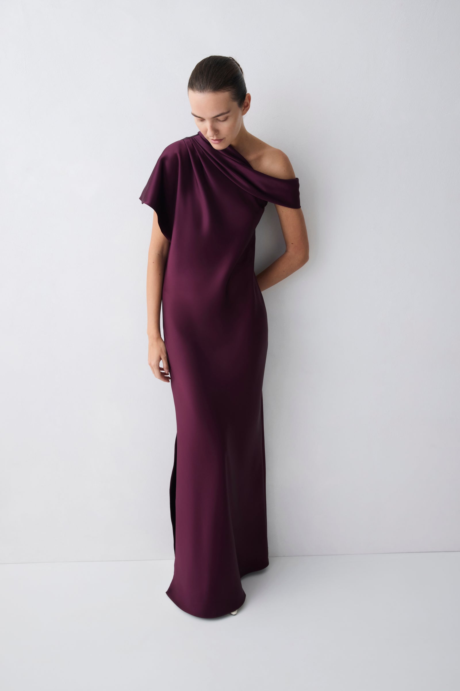 Woman wearing a purple off-shoulder gown against a white background