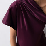 Purple draped dress on a plain background
