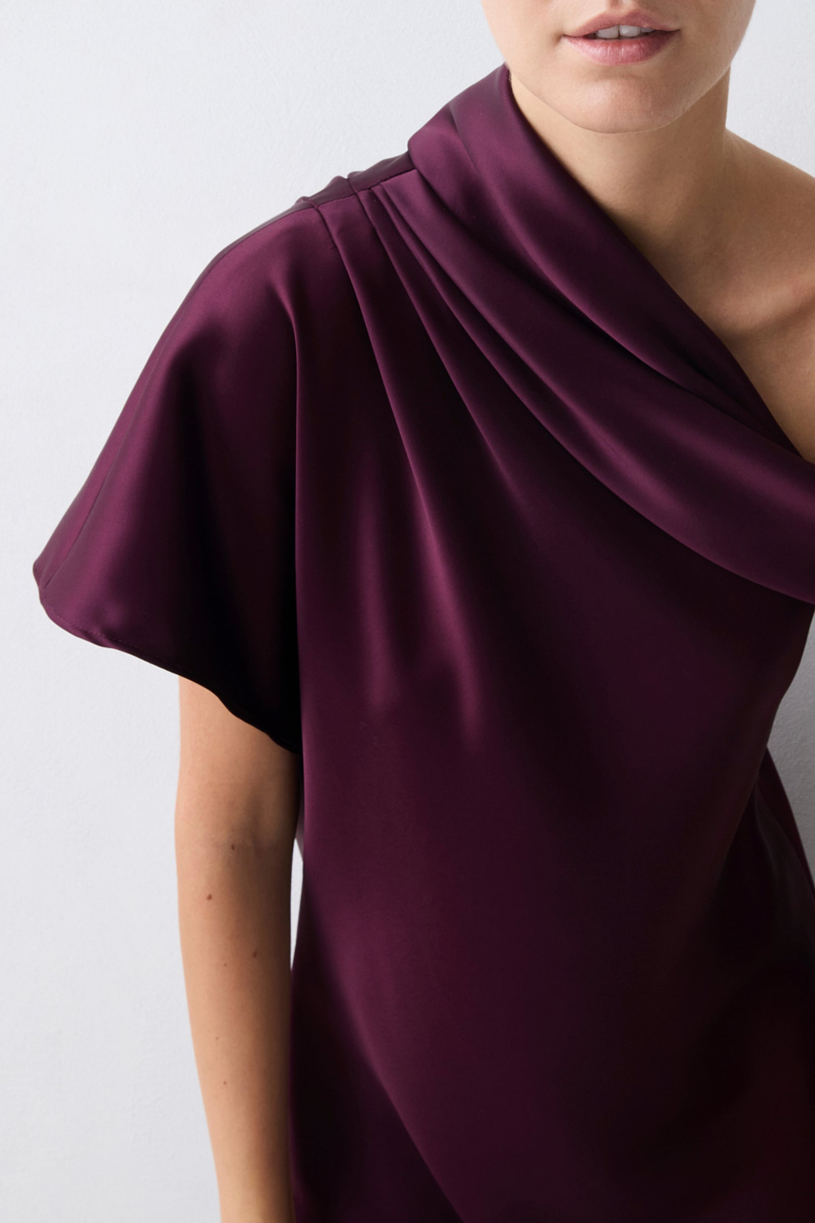 Purple draped dress on a plain background