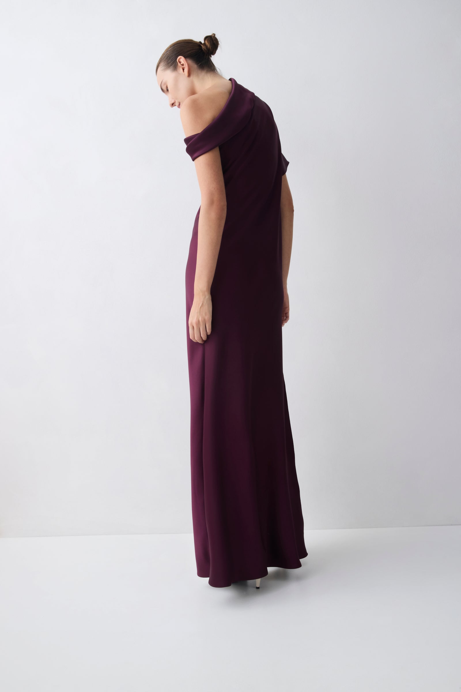 Woman wearing a long purple dress against a white background