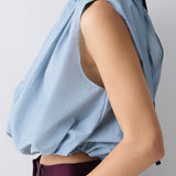 Light blue sleeveless top worn by a person on a plain background