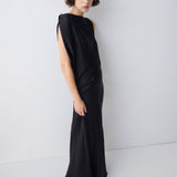 Woman wearing a black one-shoulder dress against a white background