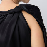 Black sleeveless top worn by a person on a plain background