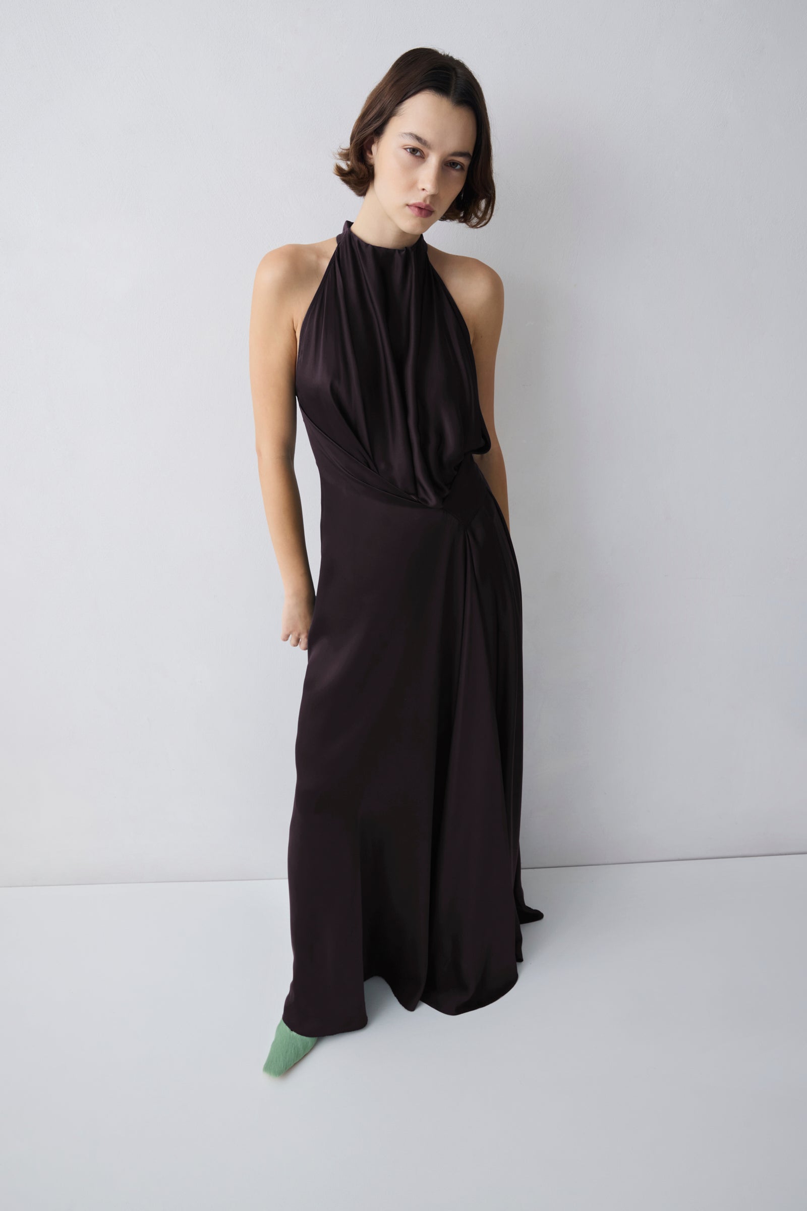 Woman wearing a black halter neck dress against a white background