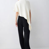 Person wearing a white top and black pants on a white background