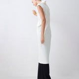 Woman wearing a white sleeveless top and black pants on a white background
