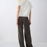 Person wearing a white off-shoulder top and dark pants on a white background