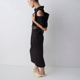 Person wearing a black outfit with sheer details on a white background
