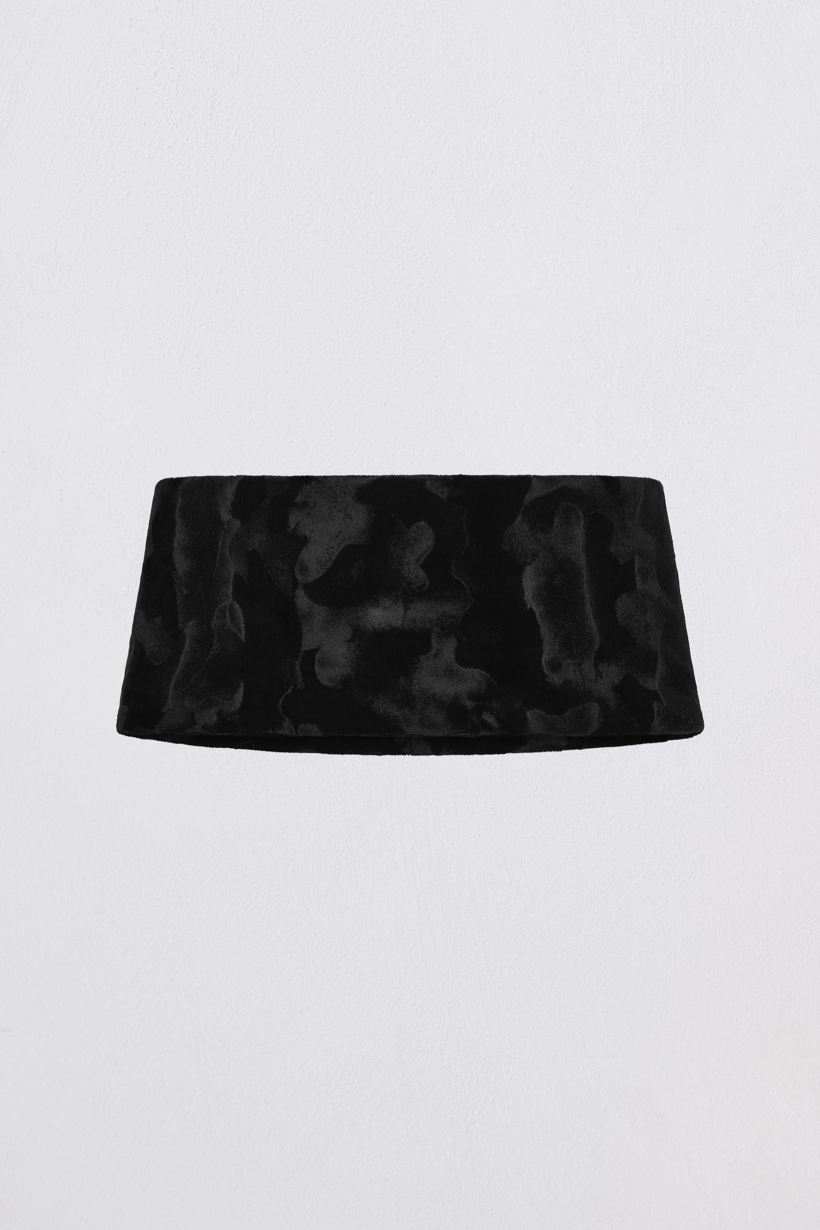 Black velvet headband on a light gray background