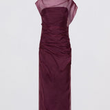 Woman wearing a purple dress with a plain white background