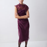 Woman wearing a purple dress with a plain white background