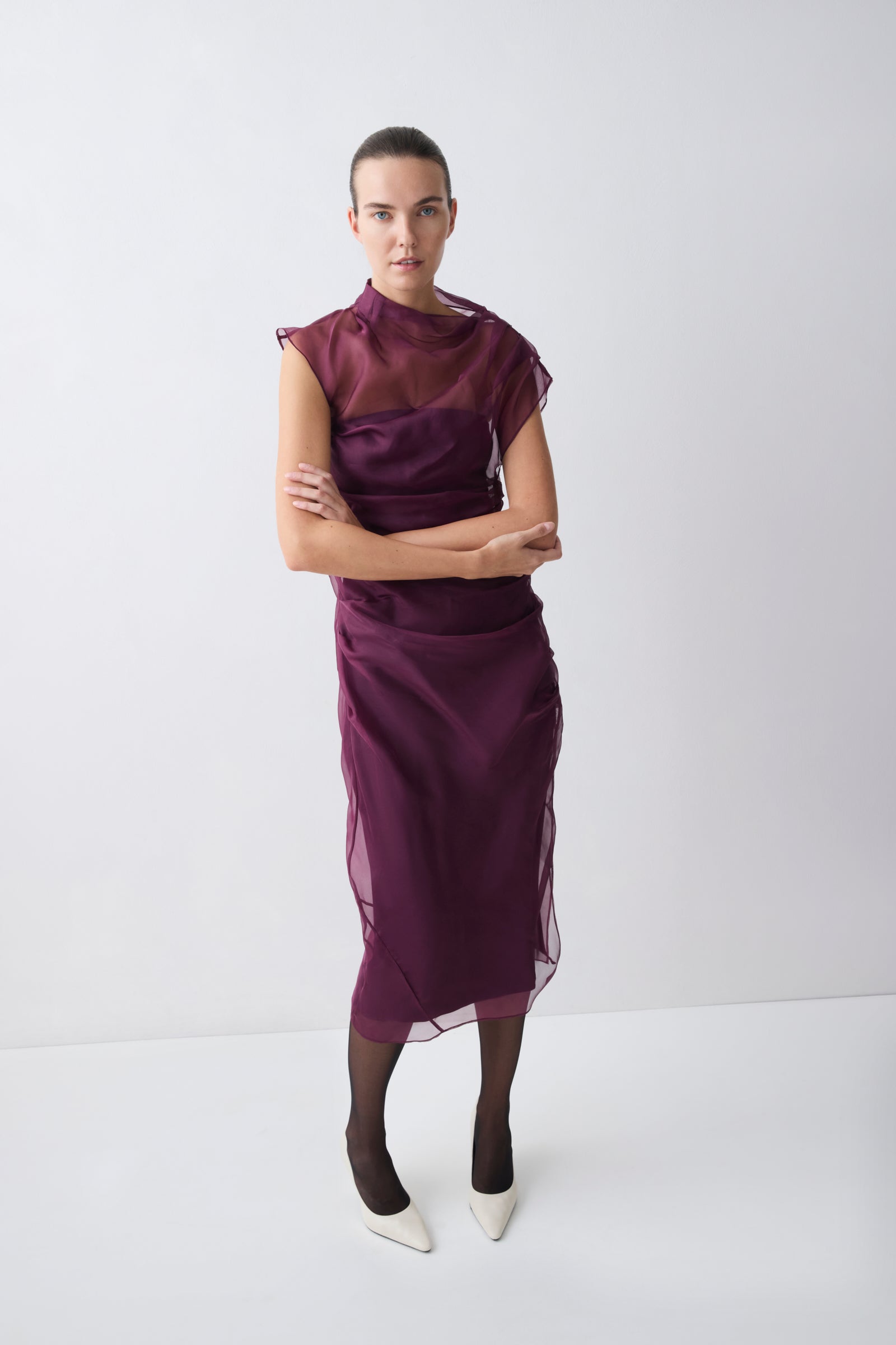 Woman wearing a purple dress with a plain white background