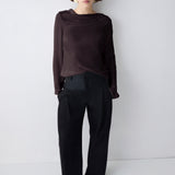 Person wearing a dark outfit against a white background