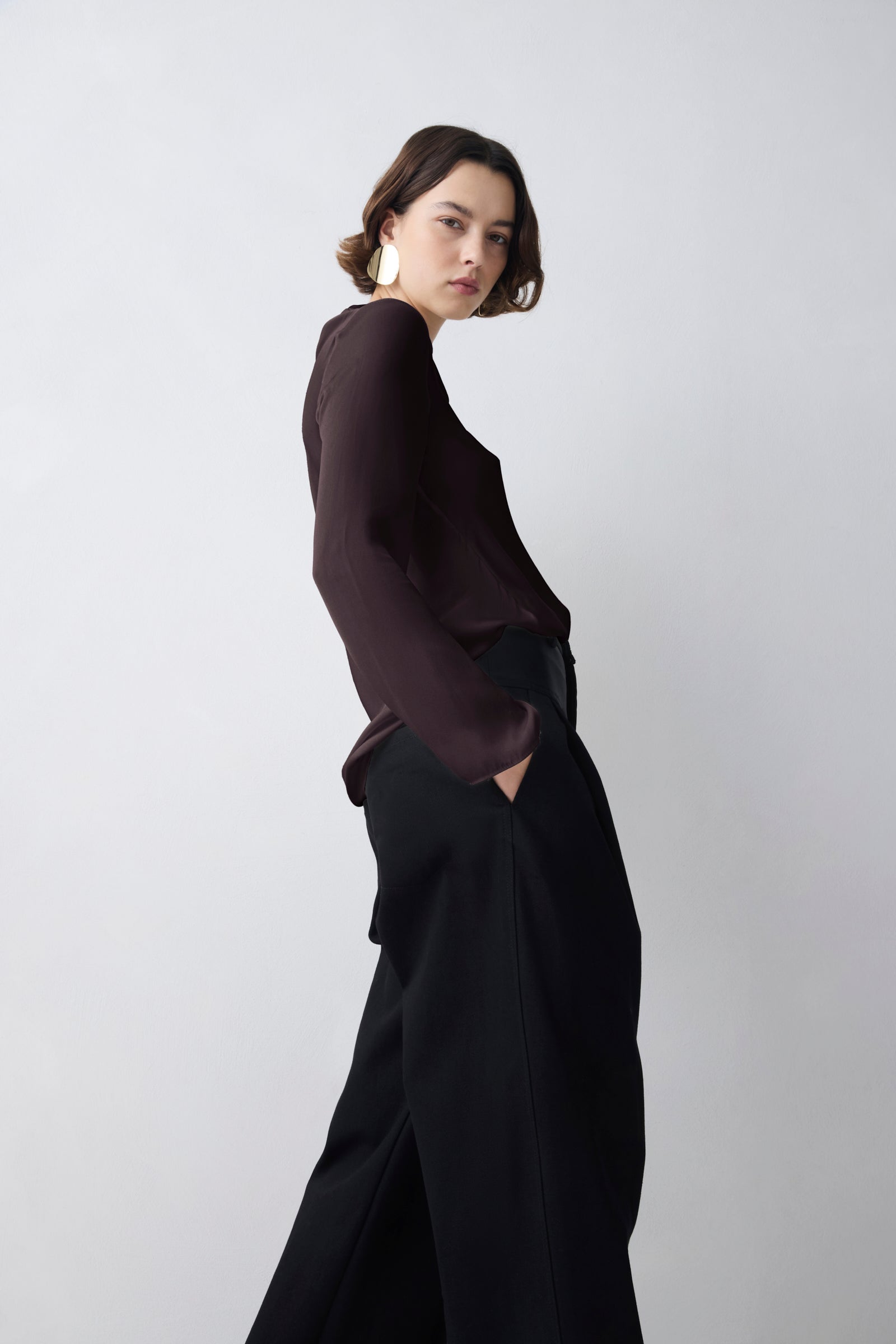 Person wearing a dark outfit against a plain background