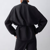 Person wearing a black outfit against a white background