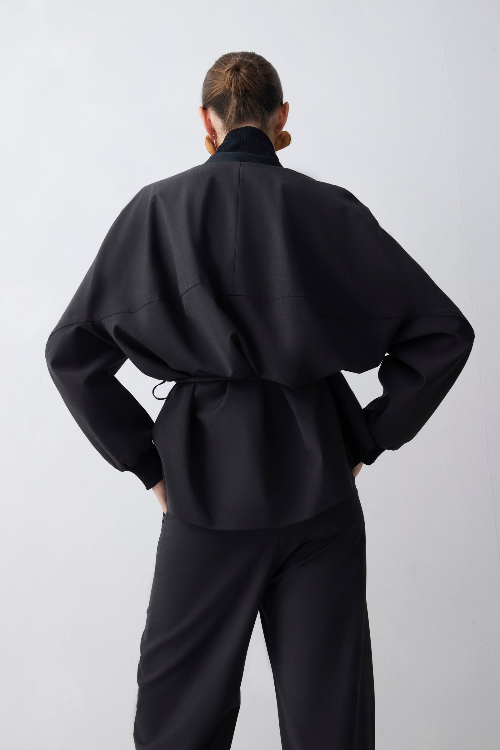 Person wearing a black outfit against a white background