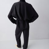 Person wearing a black outfit against a white background