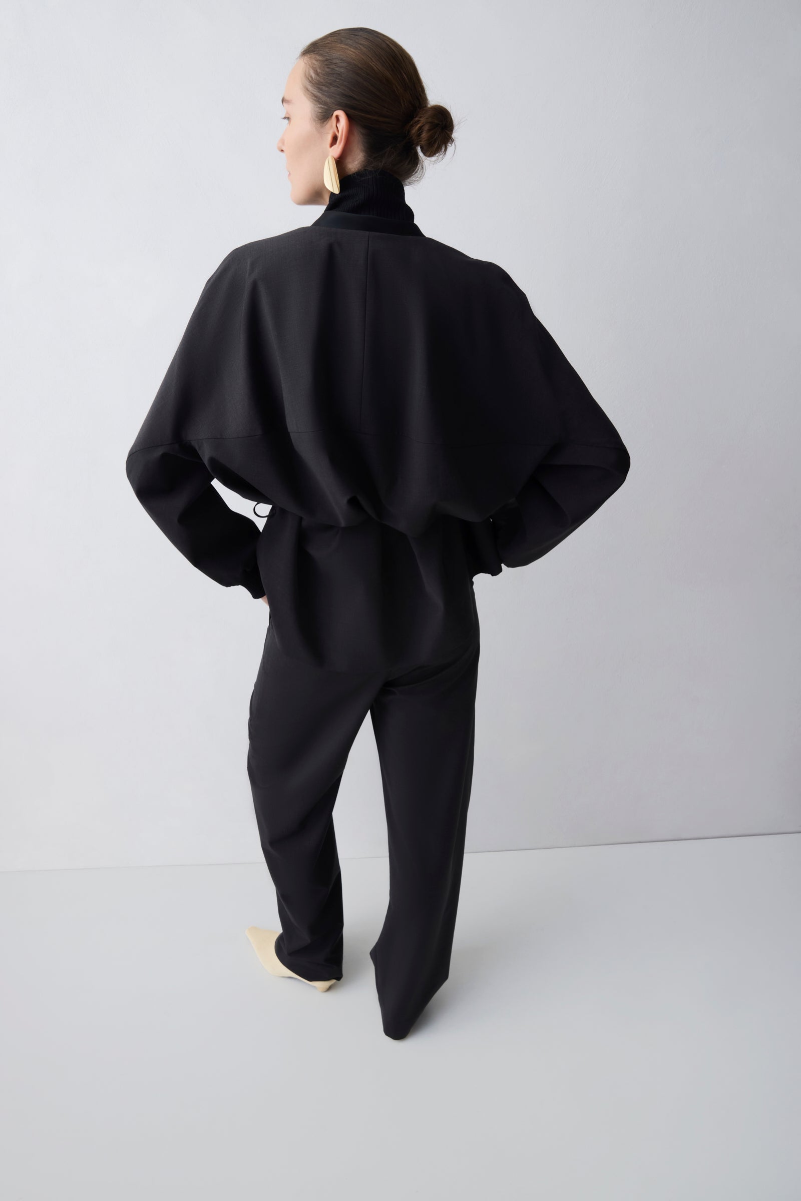 Person wearing a black outfit against a white background