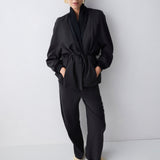 Person wearing a black outfit against a white background