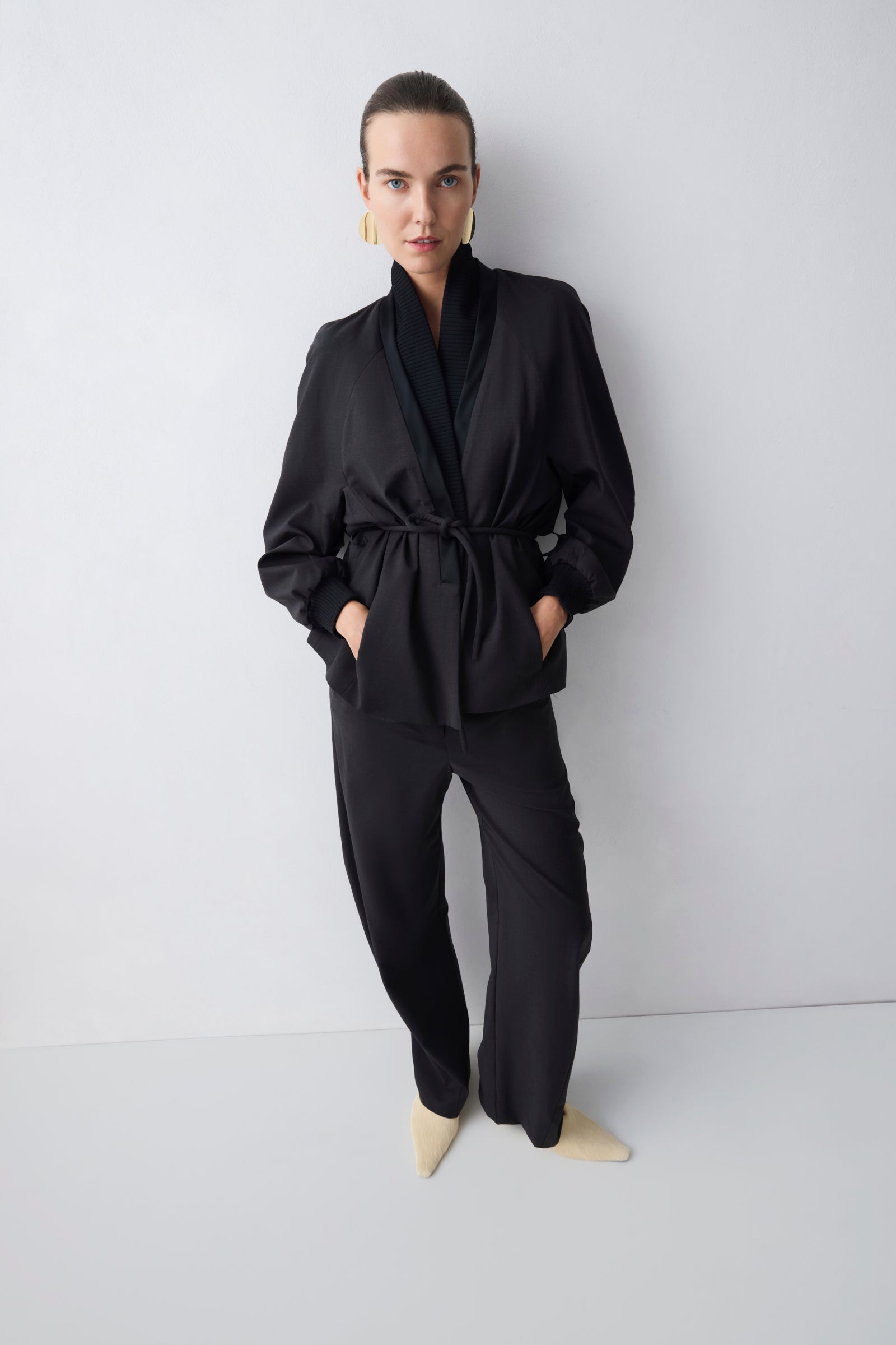 Person wearing a black outfit against a white background