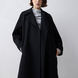 Person wearing a black coat on a white background