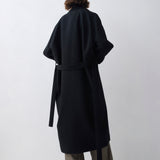 Person wearing a black coat from behind on a white background