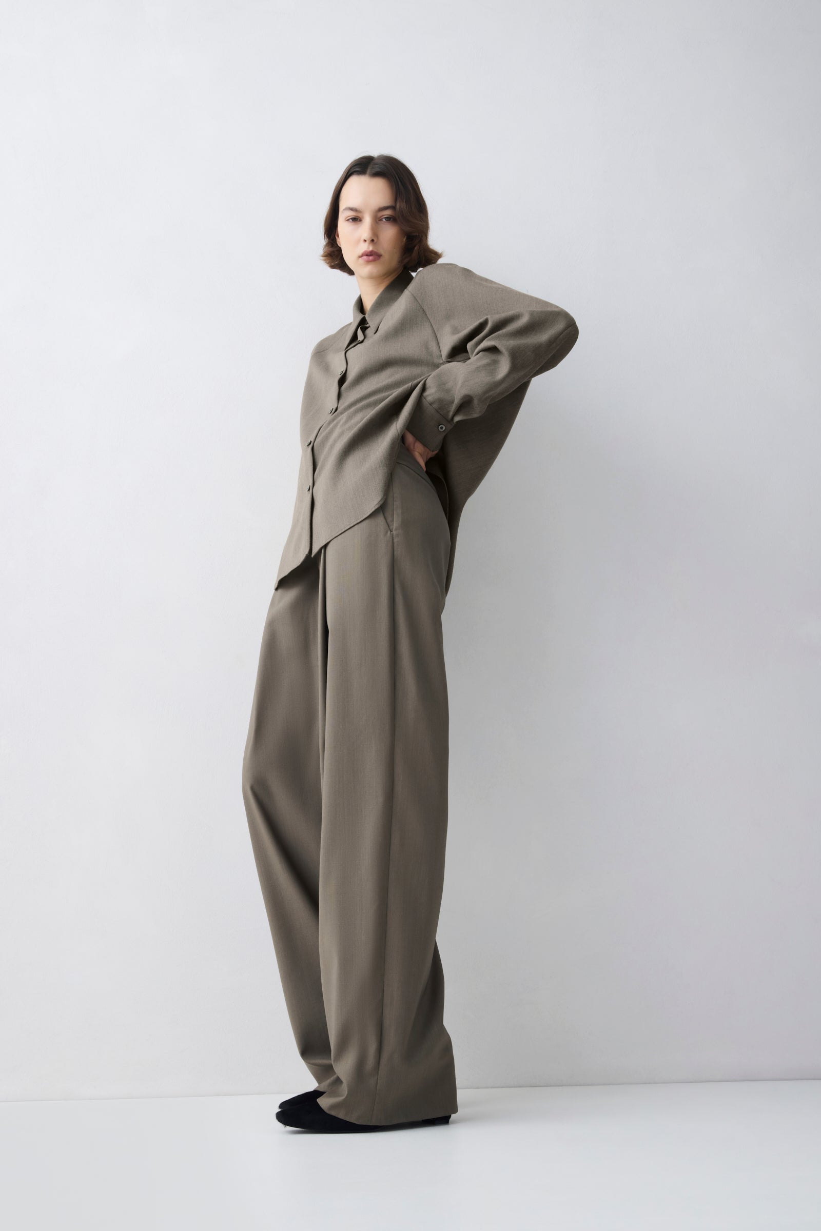 Person wearing a beige suit against a white background