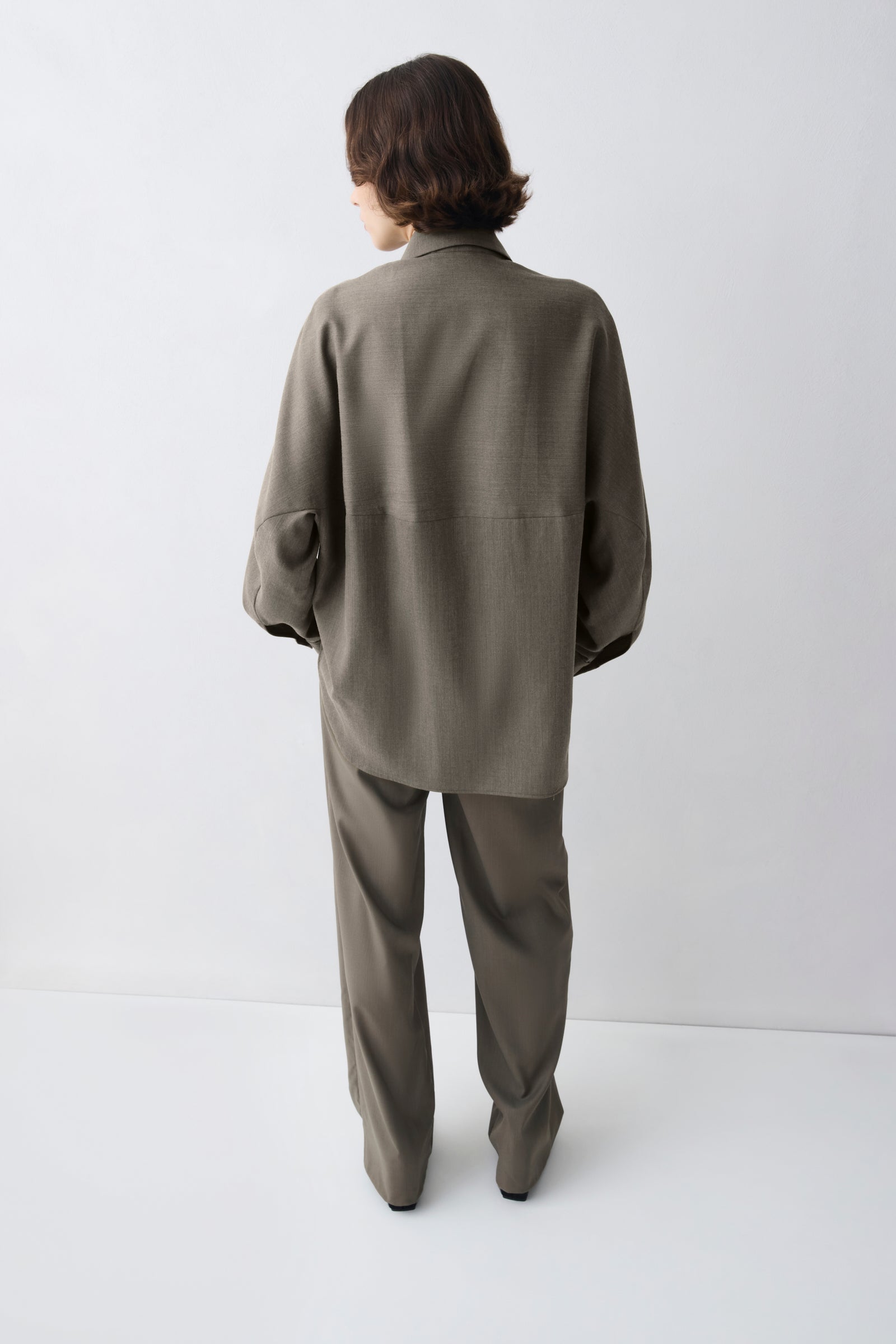 Person wearing a green suit against a white background