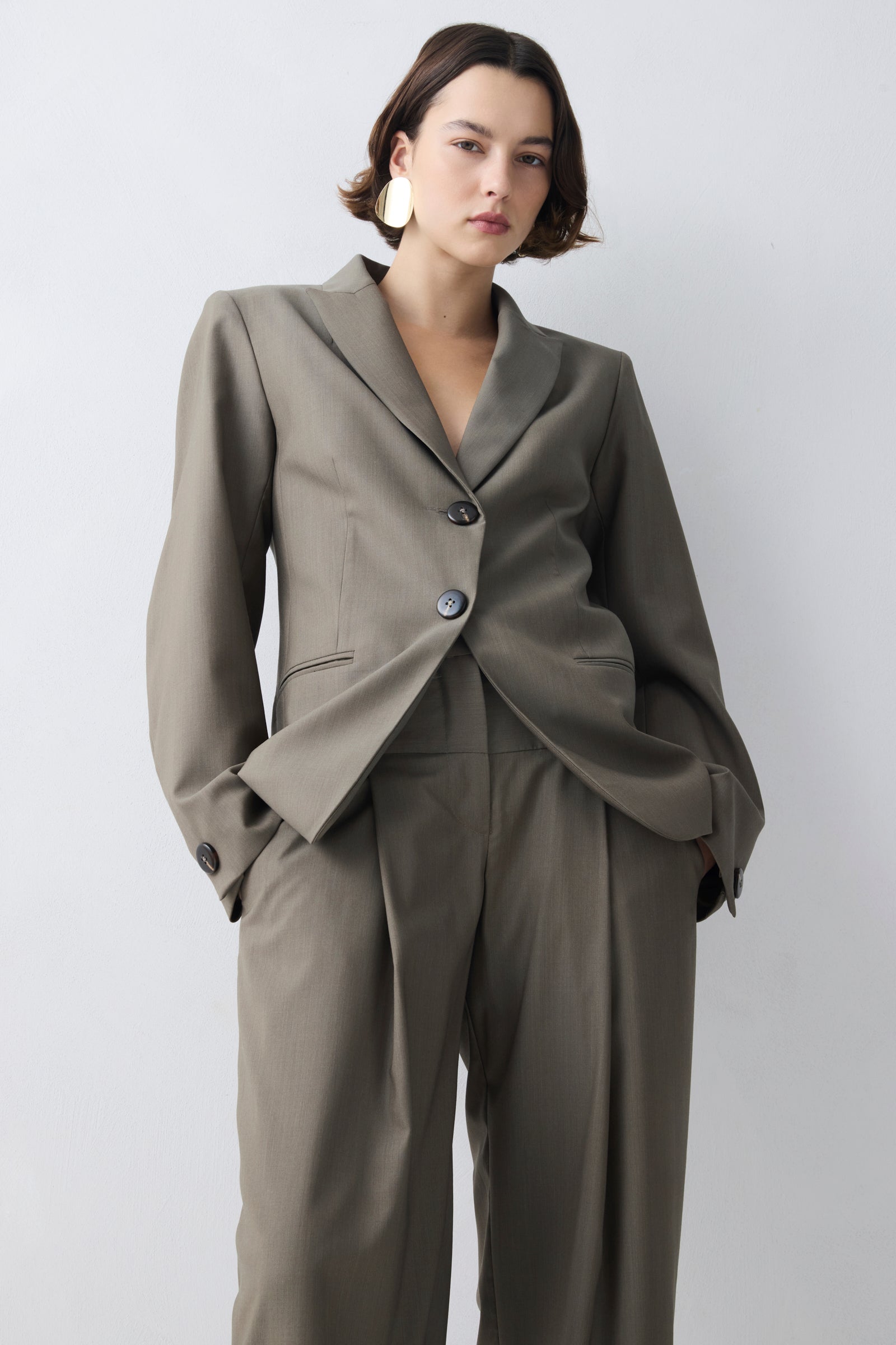 Woman wearing a gray suit with a white background