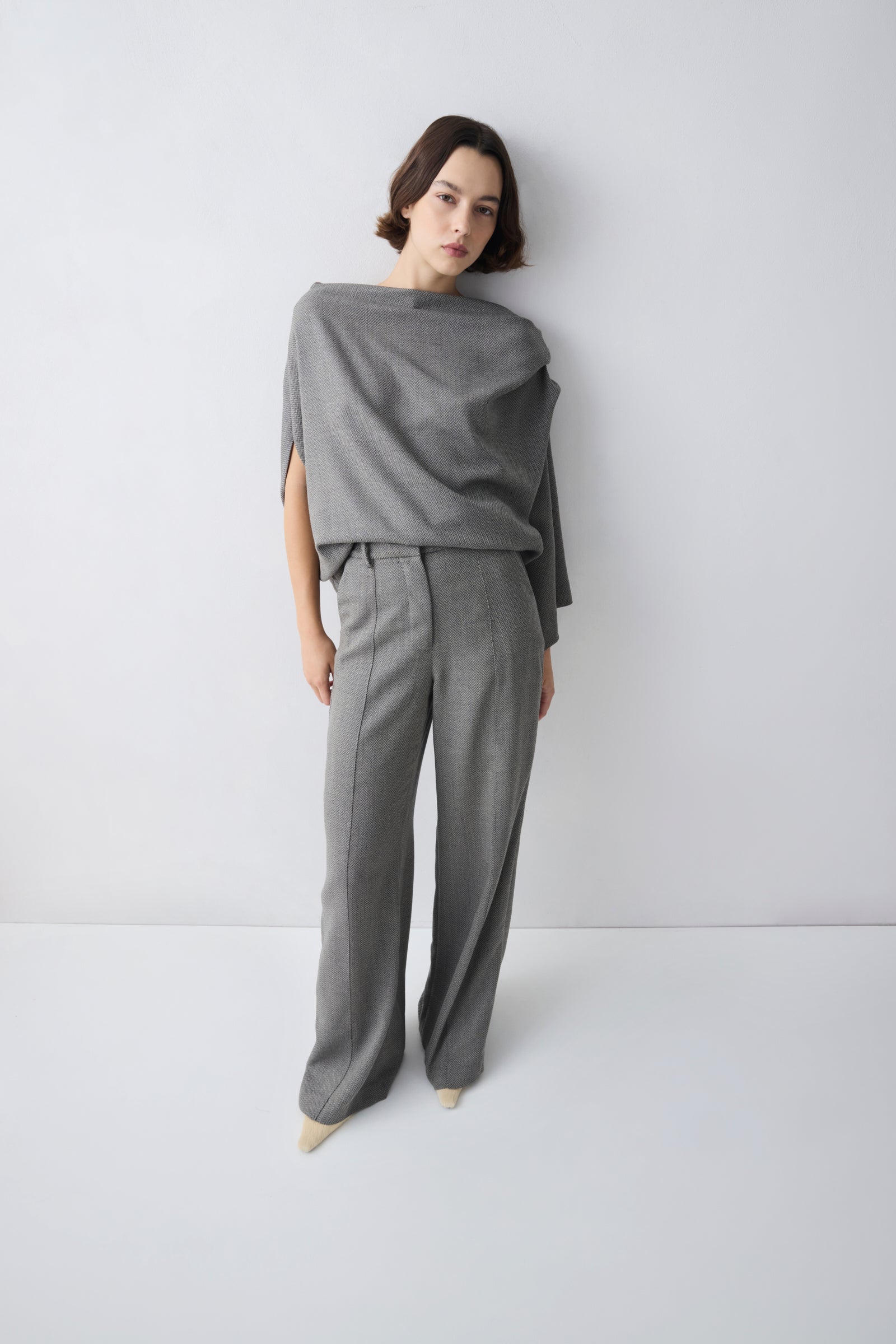 Person wearing a grey outfit on a white background