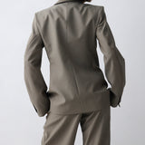Person wearing a gray suit against a white background