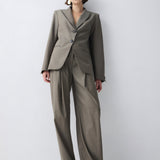 Woman wearing a beige suit against a white background