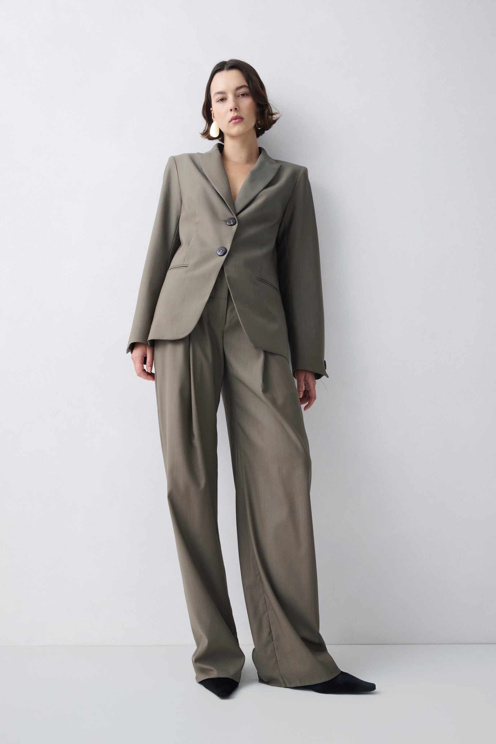 Woman wearing a beige suit against a white background