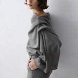 Woman wearing a grey outfit against a white background