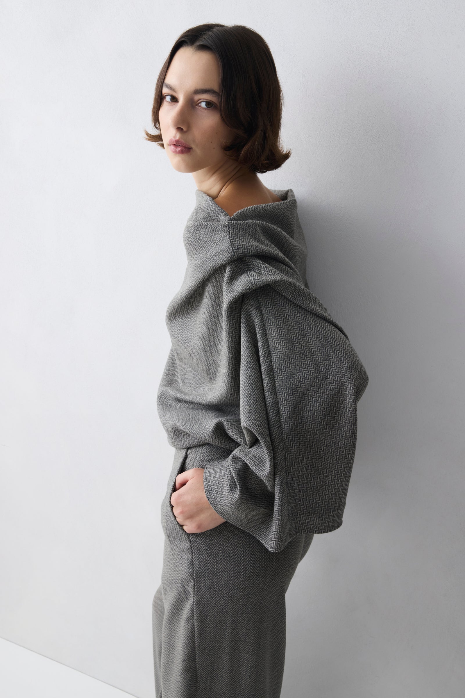 Woman wearing a grey outfit against a white background