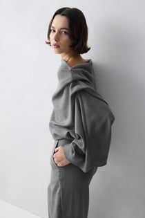 Woman wearing a grey outfit against a white background