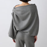 Person wearing a gray off-shoulder top and pants on a white background
