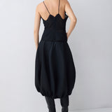 Person wearing a black dress with a plain background