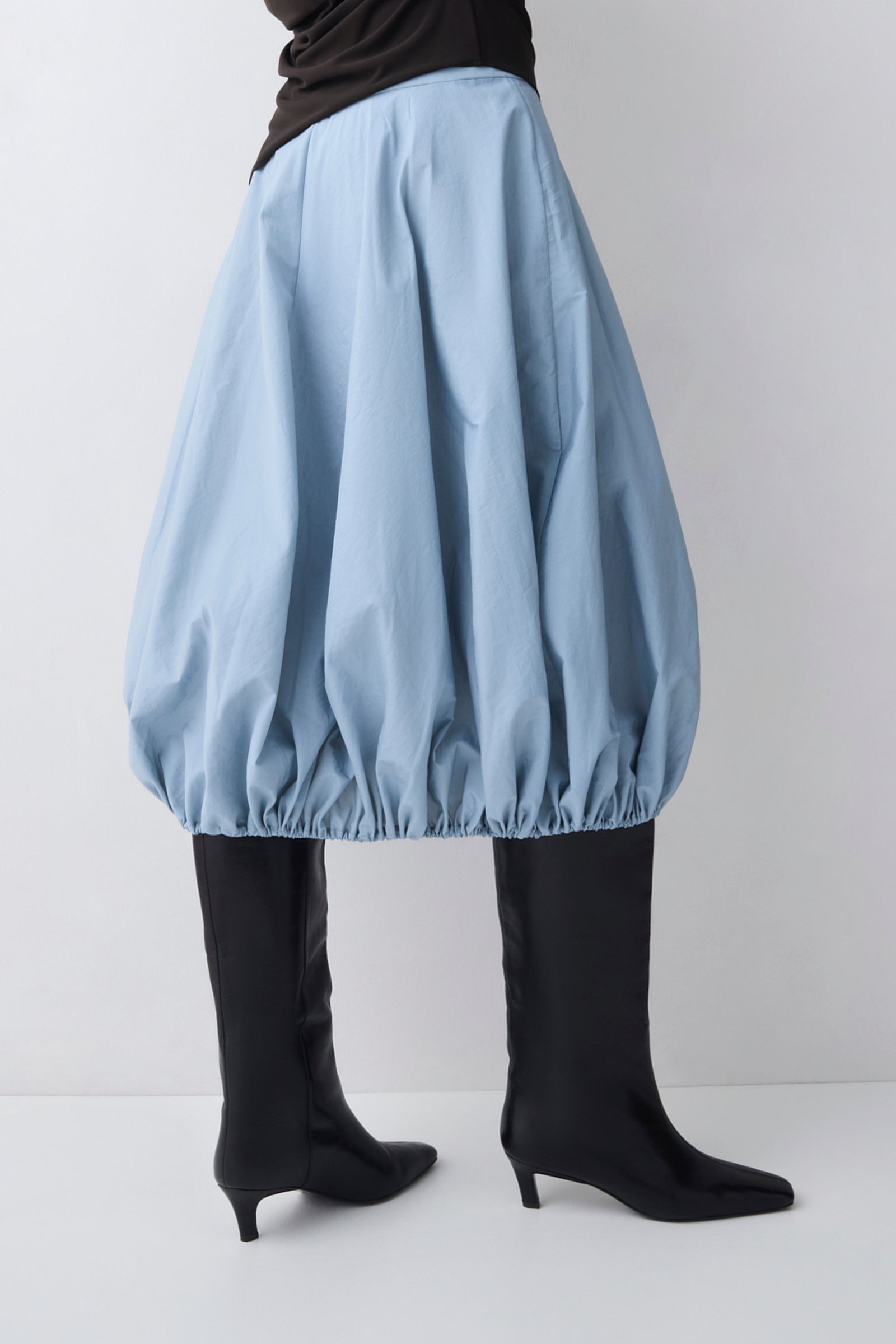 Light blue bubble skirt worn by a person on a white background
