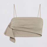 A light beige asymmetrical draped tube top with thin spaghetti straps, shown against a plain white background.