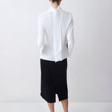 Person wearing a white shirt and black skirt on a white background